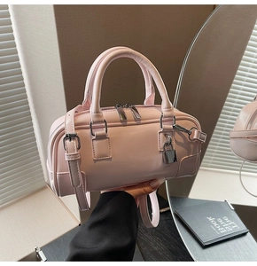 Detail of pink mini Boston bag with shiny PU leather finish and silver padlock pendant