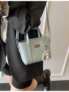 Light blue lychee textured crossbody bucket bag with pearl charm and golden nameplate