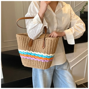 Détail d'un sac cabas en paille avec cordes torsadées multicolores et anses en cuir marron