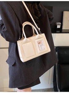 Minimalist cream white bucket bag with transparent card slot and adjustable shoulder strap