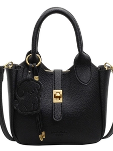 Black lychee leather bucket bag with gold hardware and a cute dog charm accessory