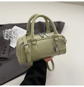 Close-up of sage green Boston handbag with silver hardware and mini padlock detail