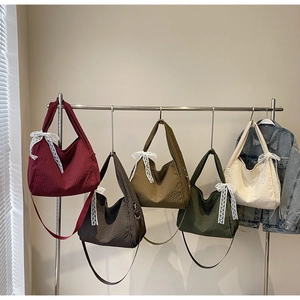Detail view of waffle texture tote bags in five colors with white lace bows and straps