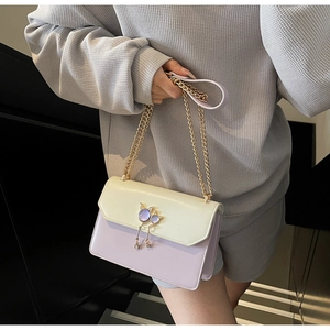 Détail du petit sac à rabat lilas avec fermoir chat en métal et bandoulière chaîne