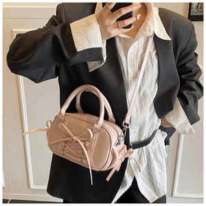Detail view of pink bow handbag showing PU leather texture and ribbon accents