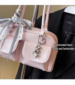 Detail of pink PU leather Boston bag with plaid bows and silver heart charm decoration