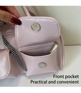 Close-up of pink Boston bag front pocket with magnetic clasp and plaid strap