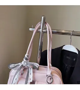 Pink bowling bag detail showing smooth PU leather texture and a checkered bow decoration