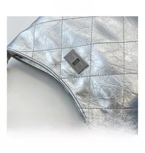 Nahaufnahme der silbernen Stepptasche mit Vintage-Textur und elegantem Metallverschluss