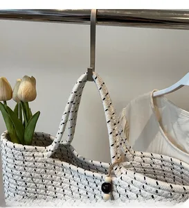 Close-up of woven straw tote bag with contrast patterns and wooden bead detail