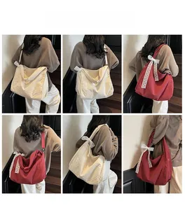 Detail view of large waffle textured tote bags with white lace bows in cream and burgundy