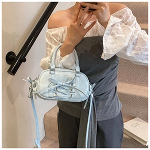 Light blue balletcore boston bag with bow detail shown in a casual lifestyle setting