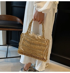 Detail der handgewebten goldenen Tasche mit cremefarbenem Innenbeutel und stabilen Griffen