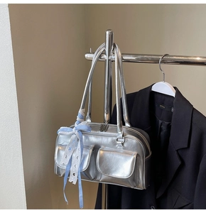 Silver metallic bowling bag with bow ribbon detail and front pockets close-up view
