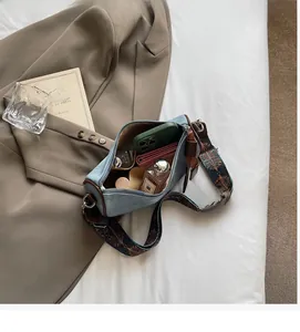 Internal view of blue denim barrel bag showing ample storage for phone and perfume