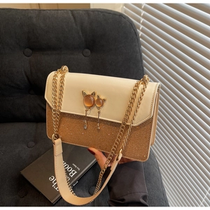Vue détaillée d'un sac bandoulière avec boucle hibou et sequins dorés brillants