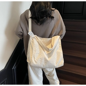 Detail of cream waffle texture fabric and delicate lace bow on large shoulder tote bag