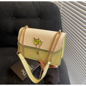 Détail du sac à bandoulière avec boucle chat en métal et pierre de couleur émeraude