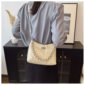 Detail der beigen Stepptasche mit Vintage-Lederstruktur und silberner Metallgliederkette