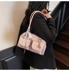 Detail of pink glossy shoulder bag with plaid ribbon and silver heart charm decoration