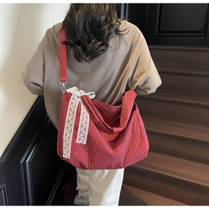Detail view of large red gingham tote bag featuring a decorative white lace bow
