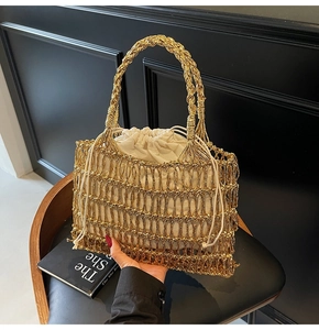 Detailaufnahme der goldfarbenen geflochtenen Handtasche mit weißem Kordelzug-Innenfutter