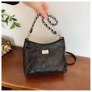 Details der schwarzen gesteppten Ledertasche mit Silberkette und Vintage-Drehverschluss