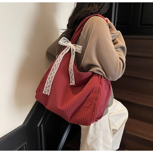 Detailed shot of red checkered canvas tote bag with white lace bow and spacious interior