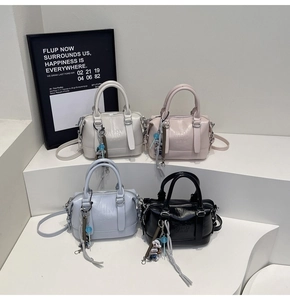 Detail view of four colorful PU leather Boston bags with bear charms and embossed logo