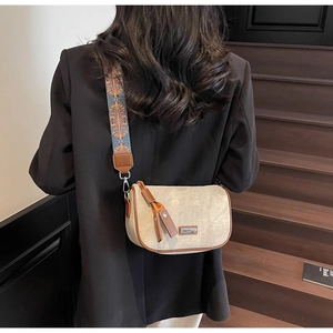 Detail of beige texture crossbody bag with colorful ethnic pattern woven strap