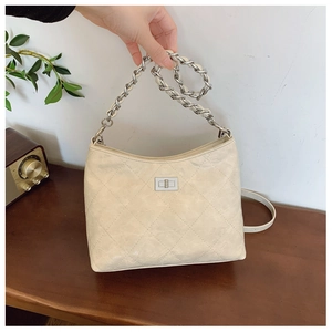 Detailaufnahme der cremefarbenen gesteppten Ledertasche mit Silberkette und Drehverschluss
