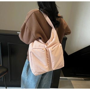 Detail of light pink large tote bag with dual front zipper pockets and wide shoulder strap