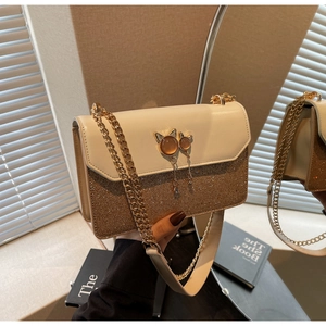 Détail de la boucle gemme oreilles de chat et du gland sur un sac à chaîne dorée