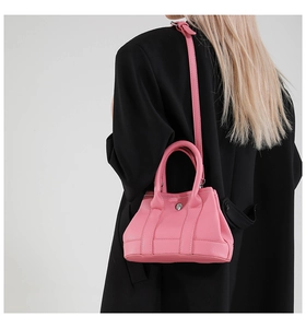 Model wearing a pink lychee pattern Lindy-style bucket bag over a black blazer jacket