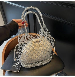 Detail der silbernen geflochtenen Netztasche mit cremefarbenem Innenbeutel auf Stuhl