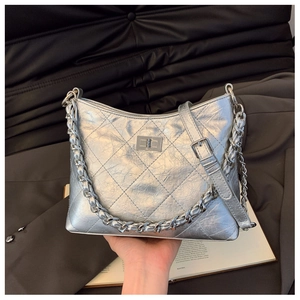 Detail der silbernen gesteppten Hobo-Tasche mit luxuriösem Drehverschluss und Kette