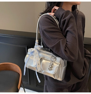 Detail view of silver Y2K shoulder bag with checkered ribbon and heart charm