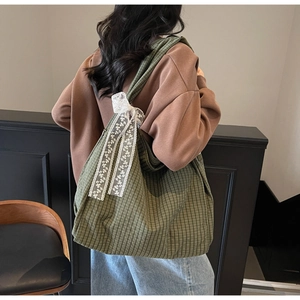Green checkered canvas tote bag with white lace bow detail shown on model back