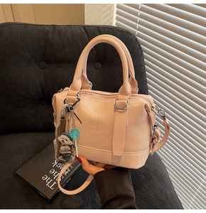 Detailed close-up of pink Boston handbag with custom embossed text and dog pendant