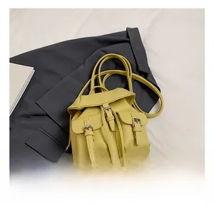 Detail of yellow lychee grain faux leather mini backpack with dual front flap pockets