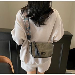 Detail of dark green matte crossbody bag with bohemian embroidery wide shoulder strap