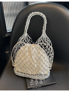 Silberne geflochtene Netztasche mit weißem Kordelzug-Inlay auf elegantem schwarzem Ledergrund