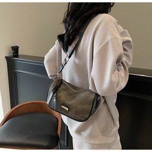 Chic olive green hobo bag with colorful embroidered wide shoulder strap shown on model