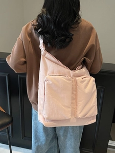 Large pink nylon crossbody tote bag with adjustable strap and dual front zipper pockets
