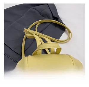 Detail of light yellow leather bag showing comfortable top handle and lychee texture