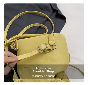 Close-up of adjustable shoulder strap on yellow litchi pattern bucket bag with metal buckle