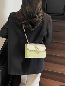Sac à bandoulière bicolore pour femme avec chaîne dorée et détail de pierre verte