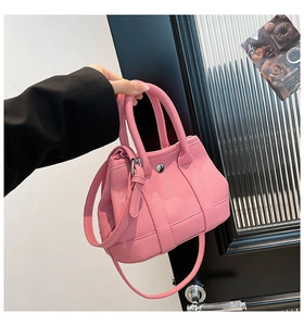Detail view of the pink lychee leather bucket bag showing silver hardware and strap