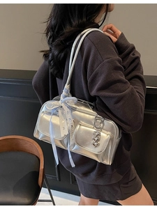 Silver metallic underarm bowling bag with dual front pockets and bow detail