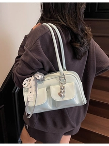 Retro minimalist bowling shoulder bag with bow detail and glossy finish on model